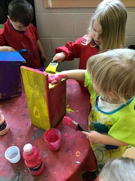 toddlers painting a bird house